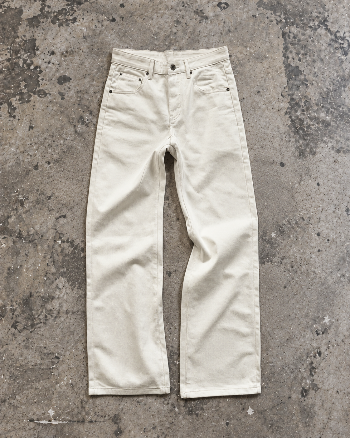 15oz Japanese denim jeans in ecru laid flat on concrete