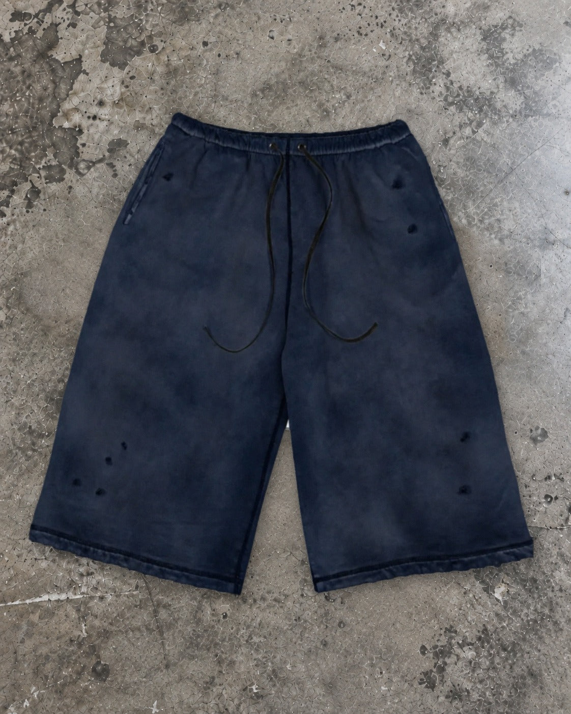 Washed 3/4 capri shorts in navy, flat lay on concrete